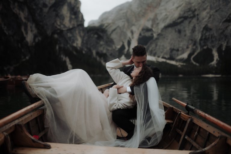 Groom kissing bride on the boat during Lake Braies Elopement in the Dolomites